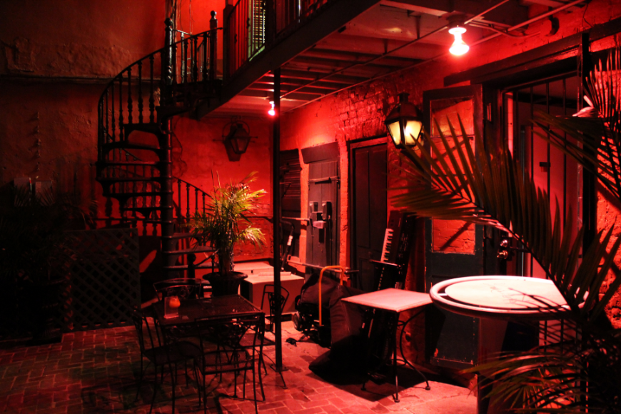 Salsa Dancing in Cuba: A sultry looking dance club with a spiral staircase is lit up red.